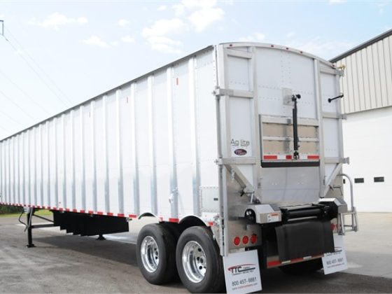 white driver side rear of belt trailer in front of shop